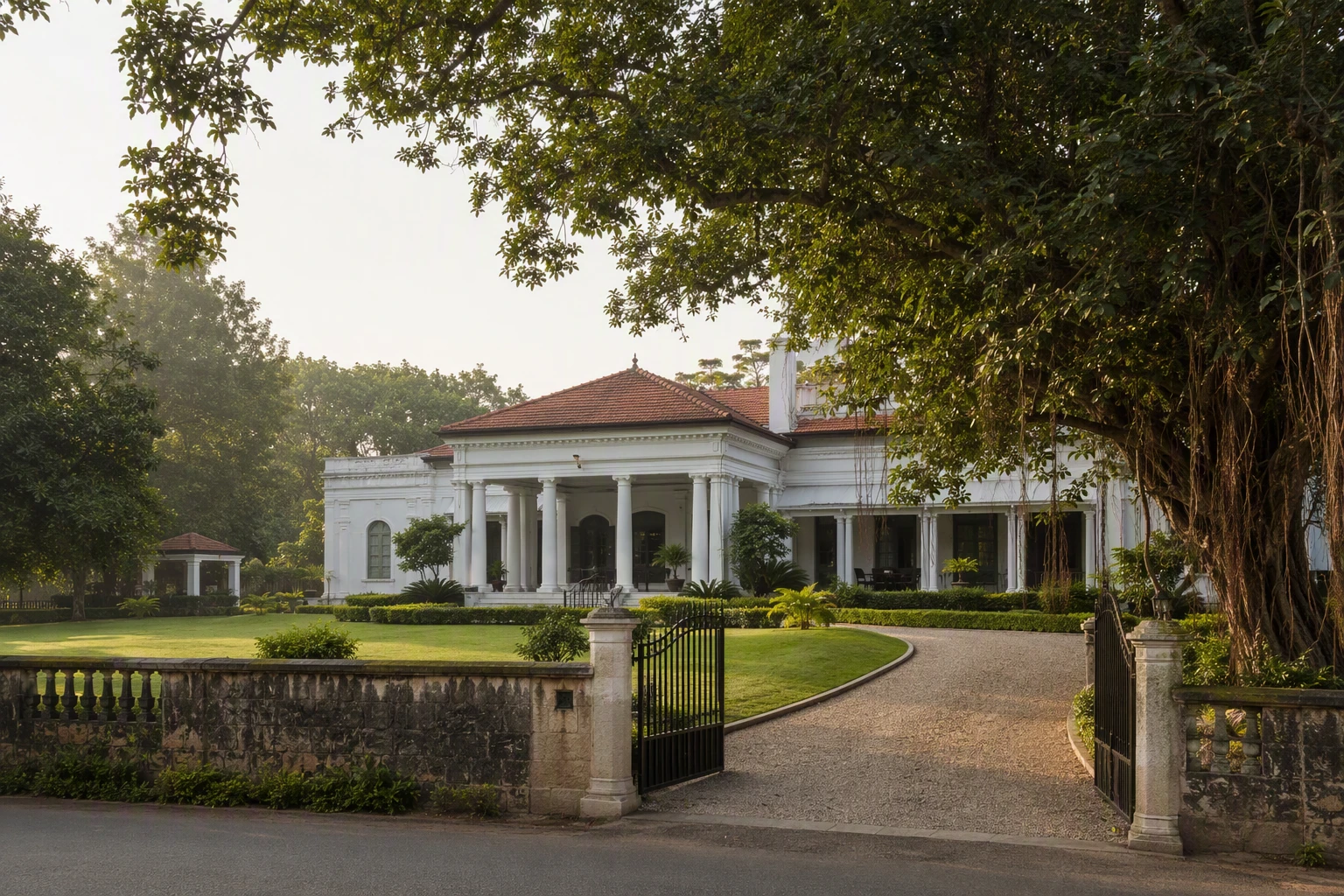 Heritage bungalow behind mature trees in morning light